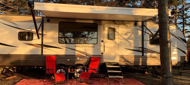 Modern RV camper with all the perks Nestled in tree at lake edge in Salmon River